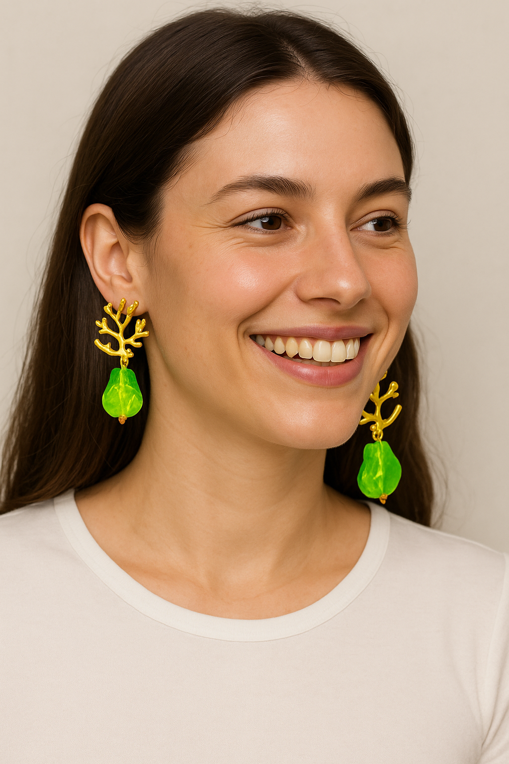 Orecchini pendenti eleganti con pietra verde a forma di doccia e dettagli dorati ramificati.